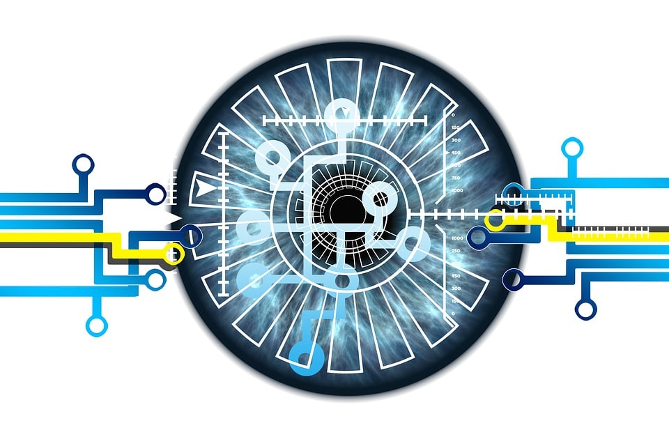 A futuristic circular design resembling an eye, with intricate blue radial lines and patterns emanating from the center. Yellow and blue circuit-like lines extend from the sides, merging into the center, suggesting a blend of technology and face recognition visualization.