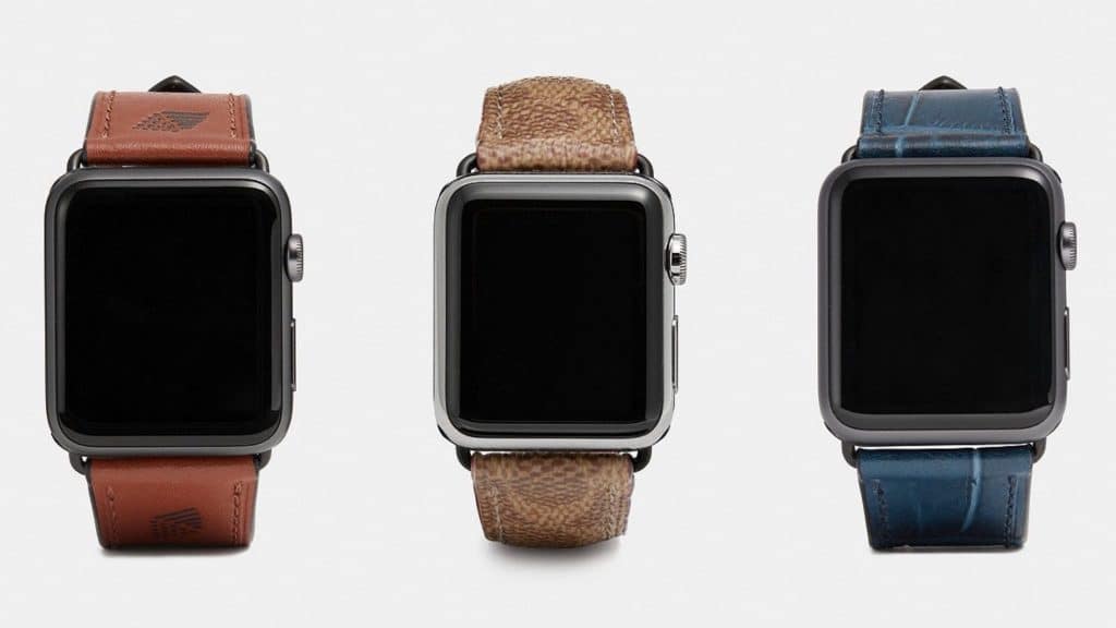 Three smartwatches with distinct leather bands are displayed side by side against a white background. The first has a brown leather band, the second features a textured light brown band reminiscent of summer Apple Watch bands, and the third boasts a blue leather band. All screens are black and turned off.