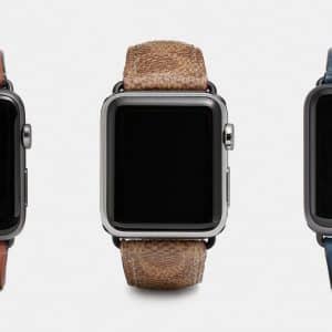 Three smartwatches with distinct leather bands are displayed side by side against a white background. The first has a brown leather band, the second features a textured light brown band reminiscent of summer Apple Watch bands, and the third boasts a blue leather band. All screens are black and turned off.