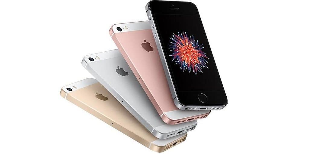 A stacked arrangement of four iPhones with different colors, including white, rose gold, gold, and black, showcasing both the back and front designs. The front screens display a colorful, flower-like explosion graphic reminiscent of the vibrant presentations seen at WWDC 18.