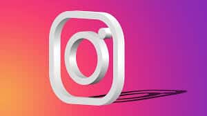 Instagram logo shown as a three-dimensional white icon on a vibrant gradient background transitioning from orange to pink to purple. The shadow of the logo is cast below it, giving a sense of depth, capturing the dynamic nature of social media and hinting at the Instagram algorithm helping users discover content.