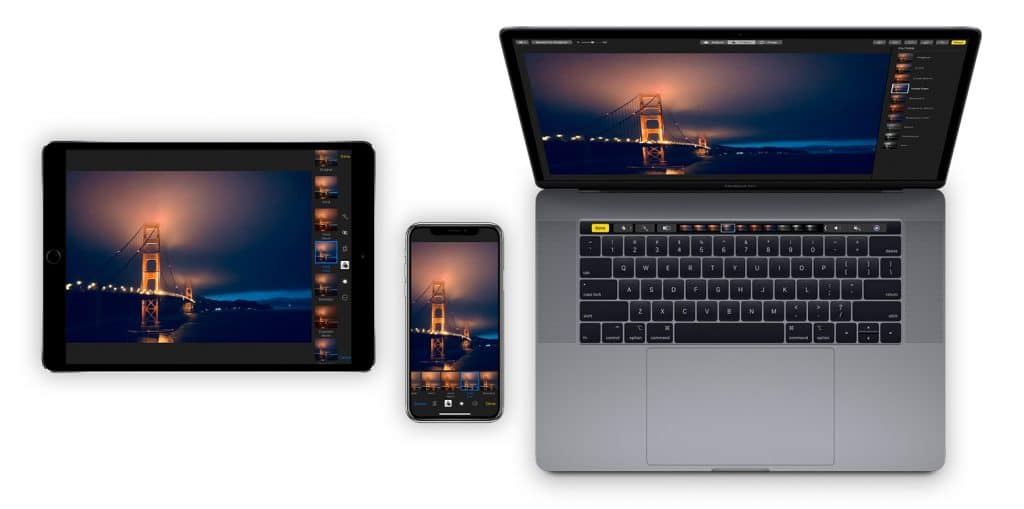 A MacBook, iPad, and iPhone are displayed side by side, each showing the same nighttime image of the Golden Gate Bridge. The MacBook screen is larger, showcasing photo editing software, while the iPad and iPhone display edited versions of the photo using the Photos app.