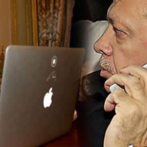 A man in business attire is seen in two scenarios: on the left, he is working on a laptop with an Apple logo in a sophisticated room; on the right, despite the iPhone boycott and American trade retaliation against Turkey, he is holding an iPhone up to his ear, engaged in conversation.