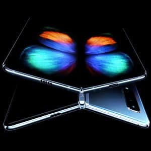 A futuristic $2,000 Samsung foldable smartphone is shown partially open in a dark environment. The screen displays a vibrant, colorful butterfly graphic. The back of the phone is sleek and metallic with a dual-camera setup.