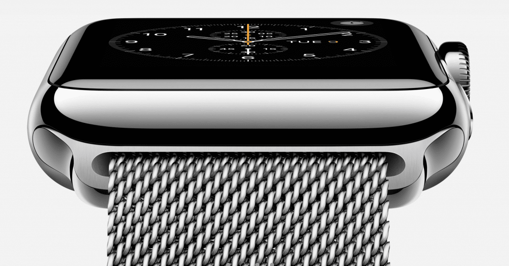 A close-up view of a sleek, silver Apple Watch with a black rectangular display showing an analog clock face with a date. The smartwatch boasts a stainless steel mesh band, and the crown is visible on the side of the watch, reminiscent of top 2018 Smartwatch Sales designs.