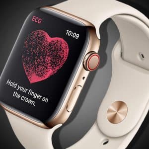 An Apple Watch with a light-colored band is displaying an ECG feature on its screen, including a heart graphic with the text "Hold your finger on the crown." The watch case is gold with a red ring around the digital crown. The time shown is 10:09.