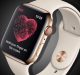 An Apple Watch with a light-colored band is displaying an ECG feature on its screen, including a heart graphic with the text "Hold your finger on the crown." The watch case is gold with a red ring around the digital crown. The time shown is 10:09.