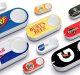 Several Amazon Dash Buttons are displayed, each branded with different logos, including Nerf, Goldfish, Burt's Bees, Starbucks Doubleshot, RedBull, Smartwater, Doritos, Tide, and Gatorade. The buttons are white with a large logo on each—a nostalgic reminder as Amazon discontinues the Dash Button line.