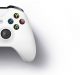 A white Xbox One S gaming controller with black joysticks and buttons is displayed against a white background. The buttons are colorful: yellow Y, blue X, green A, and red B. There is a black directional pad on the left and Microsoft brand markings on the top center.