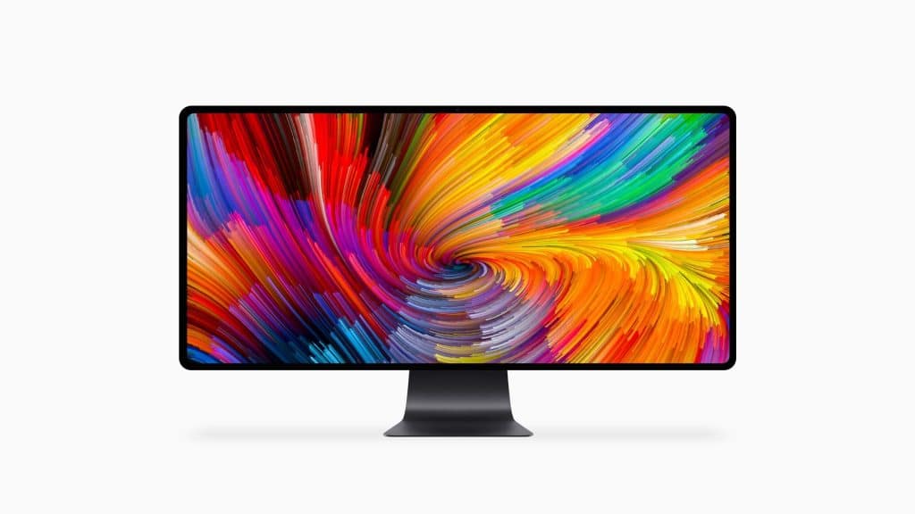 A sleek 6K monitor with a black stand displays a vibrant, colorful abstract swirl pattern. The design features a dynamic mix of red, yellow, orange, blue, and purple hues converging towards the center. The background is plain white—truly headline-worthy tech showcased at WWDC19.