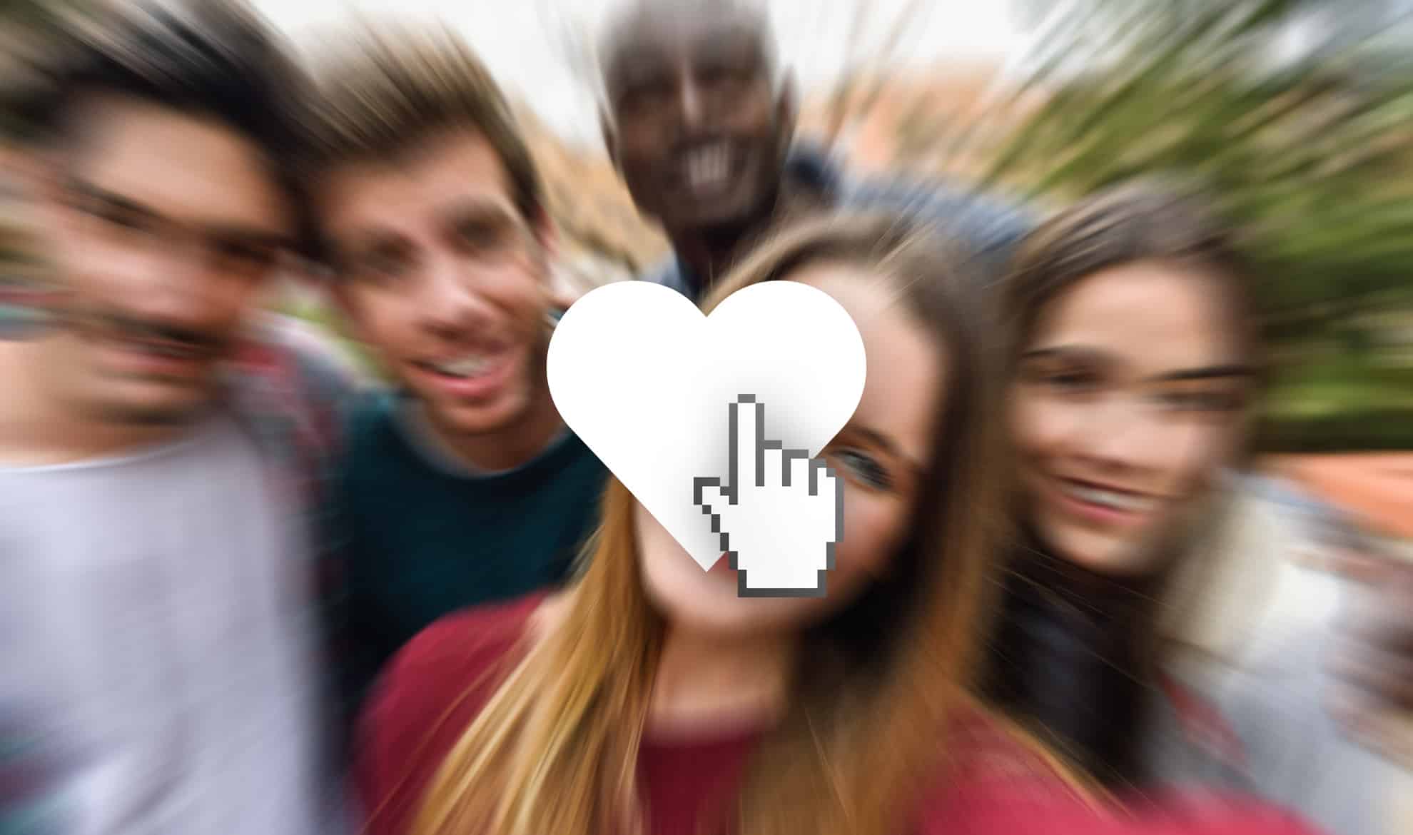 A blurred group selfie of five people with a large white heart icon and a pixelated cursor hand superimposed in the center, reminiscent of social media's "Like Me" culture. The background is out of focus, emphasizing the icon in the middle. The group appears to be outdoors.