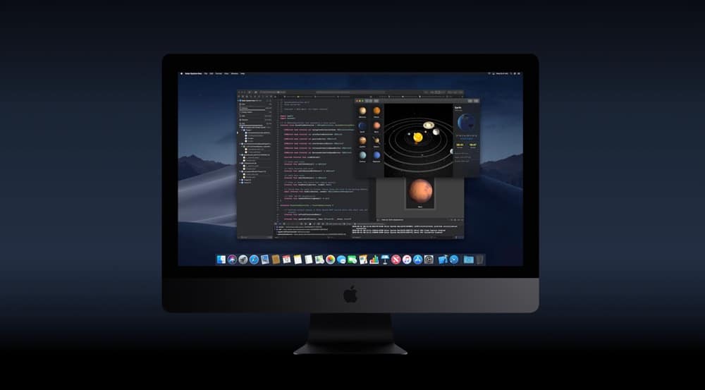 A desktop computer screen displays a coding environment with a dark-themed code editor, showing various lines of code. A smaller window overlays the editor, depicting a solar system model. The background is dark, the operating system is macOS, with Apple Music and Apple TV apps visible in the dock.