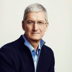 A man with short gray hair and glasses is wearing a blue shirt and a dark jacket. He is looking directly at the camera with a neutral expression. The background is plain and light-colored, reflecting his composed demeanor—one that often accompanies success and innovation.