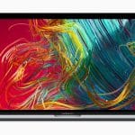 A MacBook Pro laptop with a colorful abstract design on the screen featuring swirling red, yellow, green, and blue lines on a red background. The laptop, one of the notable MacBook Pro models known for its advancements, is shown on a plain white background.