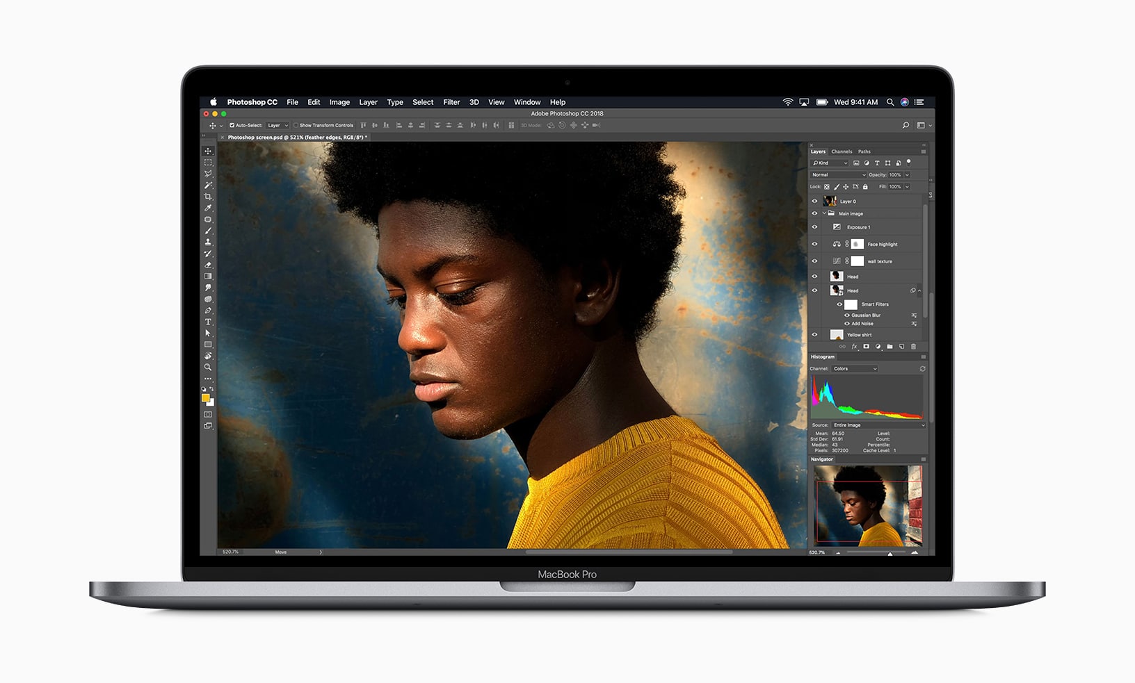 A MacBook Pro, Apple's fastest Mac notebook, displays an image editing program with a photograph of a person in a yellow sweater. The person, with curly hair, is looking down, and the background has a textured, artistic design. Editing tools and layers are visible on the screen.