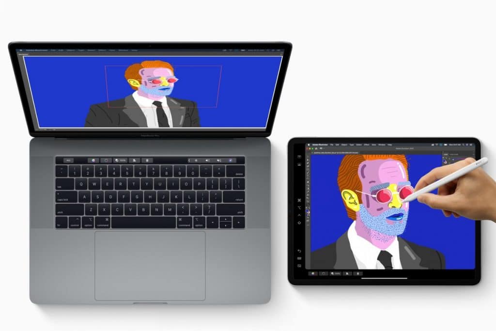 A laptop and an iPad are displayed side by side. The laptop shows an image editing program with colorful pop art of a suited man wearing glasses. A hand uses a stylus on the iPad to edit the same image, highlighting the seamless cross-device workflow enabled by macOS Sidecar.