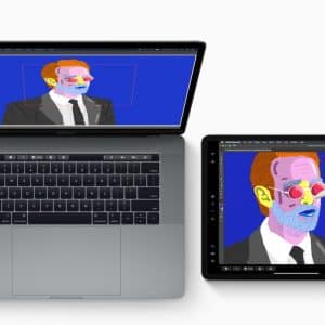 A laptop and an iPad are displayed side by side. The laptop shows an image editing program with colorful pop art of a suited man wearing glasses. A hand uses a stylus on the iPad to edit the same image, highlighting the seamless cross-device workflow enabled by macOS Sidecar.