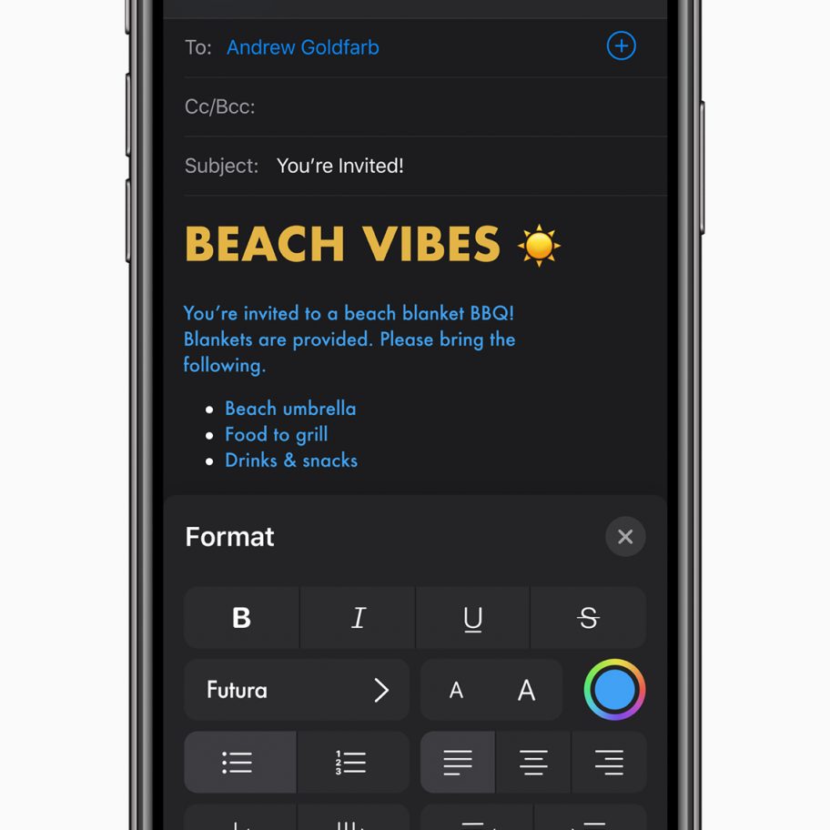 A smartphone screen displays an email draft. The subject reads "BEACH VIBES 🌞." The body of the email invites the recipient to a beach blanket BBQ and lists items to bring: beach umbrella, food to grill, drinks & snacks. Text formatting options are visible below, reminiscent of iOS 13's clean design.