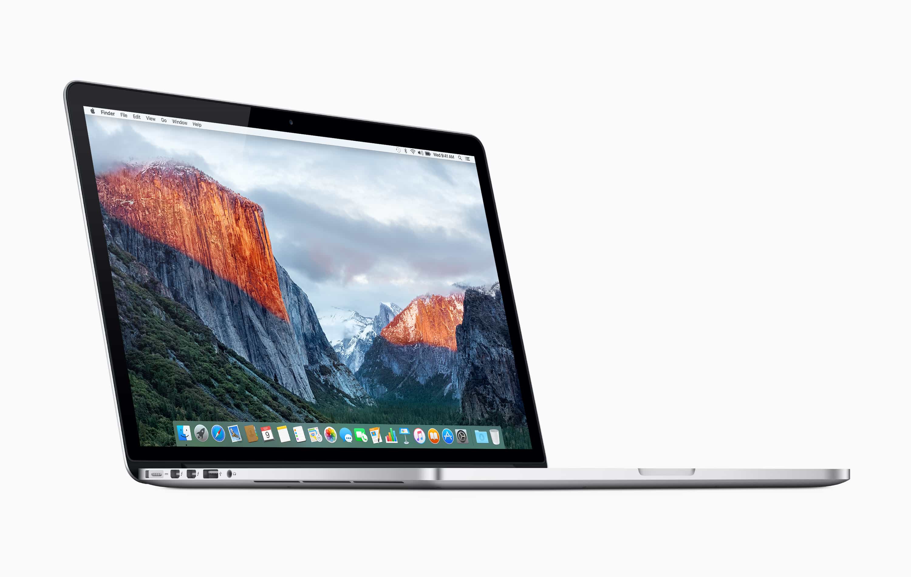 A silver MacBook Pro laptop displaying a mountainous landscape on its screen. The laptop is viewed from a slightly angled side perspective, showing part of the keyboard and trackpad, with several ports visible on the left edge, despite recent battery concerns prompting a recall. The background is white.