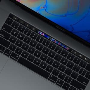 A close-up view of a MacBook keyboard, featuring a sleek black design with a touch-sensitive OLED bar above the keys. The screen displays a vibrant, abstract pattern in blue and purple colors. Part of the Apple Pro lineup, it includes standard keys and additional function keys.