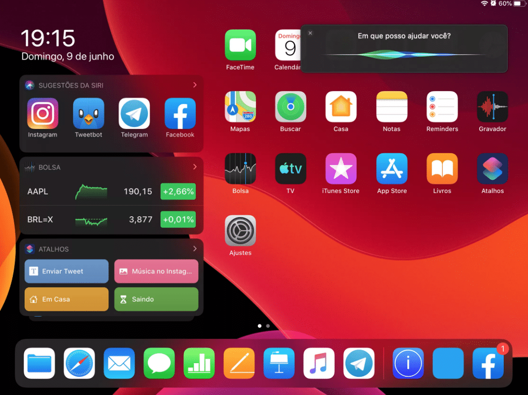 A tablet home screen displaying various apps such as Instagram, Twitter, and Facebook within an iPadOS interface. The time is 19:15 on Sunday, June 9. Siri is activated with the message, "Em que posso ajudar você?" (How can I help you?).