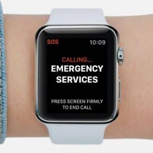 A Chicago man wearing an Apple Watch sees an alert screen on his wrist displaying "CALLING... EMERGENCY SERVICES." The screen shows "SOS" and the time "10:09" at the top. Instructions to press the screen firmly to end the call are shown at the bottom, potentially saving him from drowning.