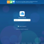 Screenshot of the iCloud sign-in page with a background of blue circles. The page prompts for an Apple ID, with options to keep signed in and links for forgotten Apple ID or password, creating an Apple ID, system status, privacy policy, terms & conditions, and copyright information. Additionally, it supports Touch ID and FaceID for secure access.