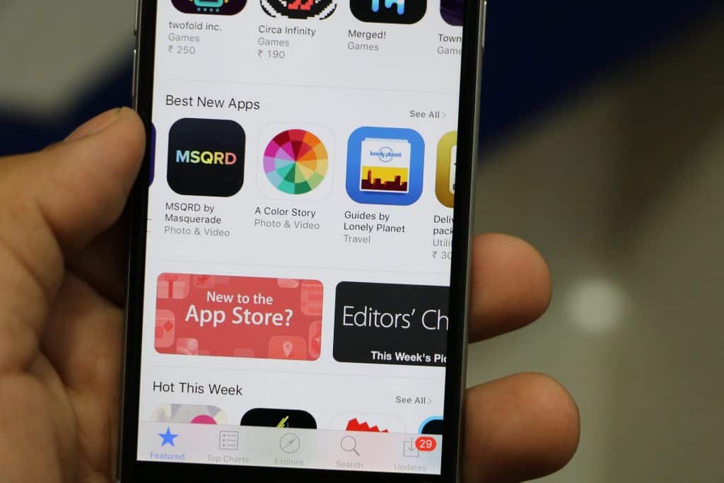 Close-up view of a smartphone screen displaying the Best New Apps section of the App Store. Visible apps include MSQRD, A Color Story, and Guides by Lonely Planet. Some app icons and a banner promoting the Apple App Store are also visible.