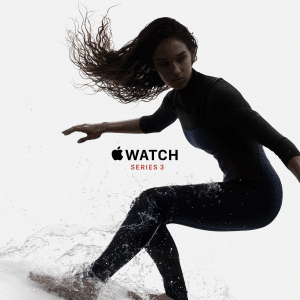 A person with long hair, wearing a wetsuit and an Apple Watch, is surfing on a wave. The background is white, and the text "Apple Watch Series 3" is displayed in the center of the image. Analysts praise its features and lower price.