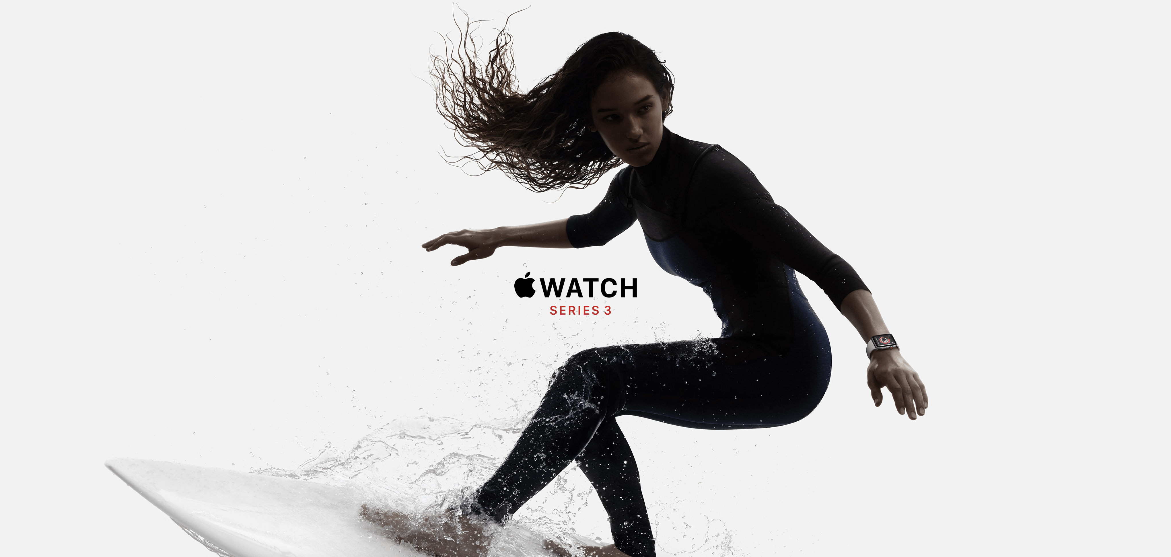 A person with long hair, wearing a wetsuit and an Apple Watch, is surfing on a wave. The background is white, and the text "Apple Watch Series 3" is displayed in the center of the image. Analysts praise its features and lower price.