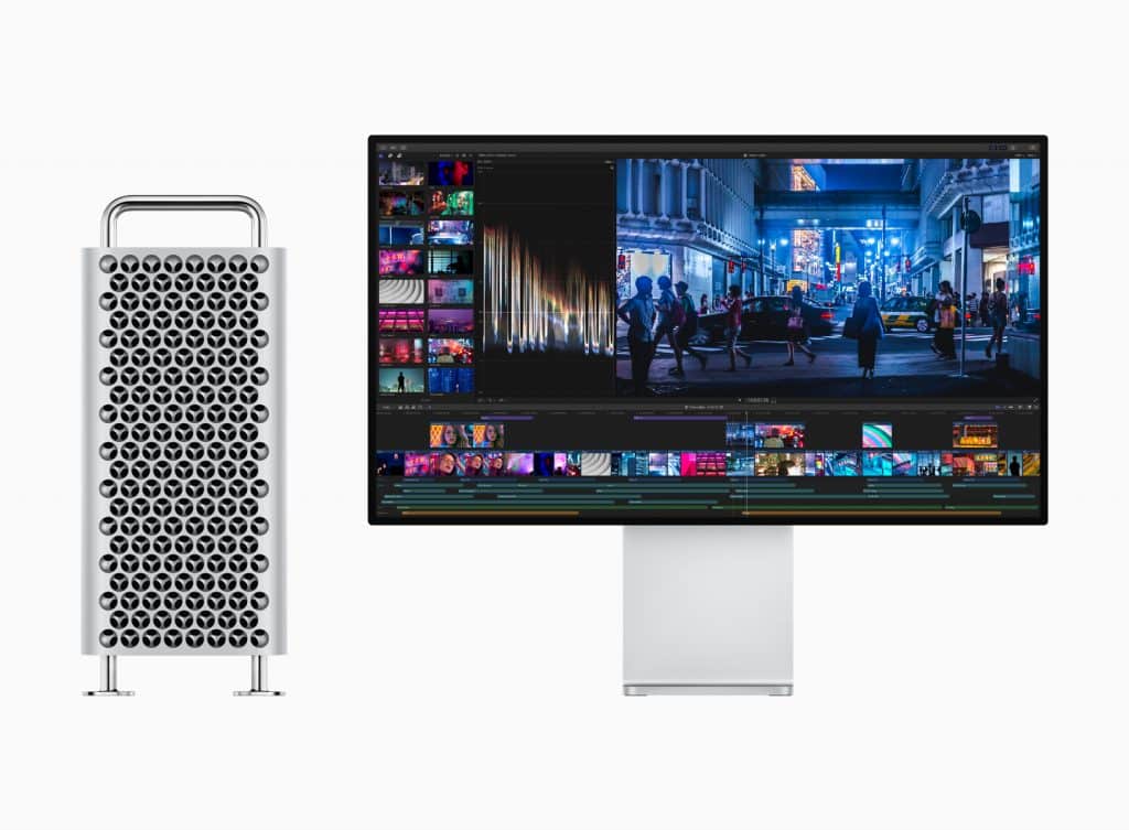 A silver computer tower with a distinctive lattice design stands left of a sleek monitor displaying a video editing interface featuring vibrant cityscape footage. The monitor is supported by a minimalist stand, reminiscent of setups unveiled at the Apple October Event.