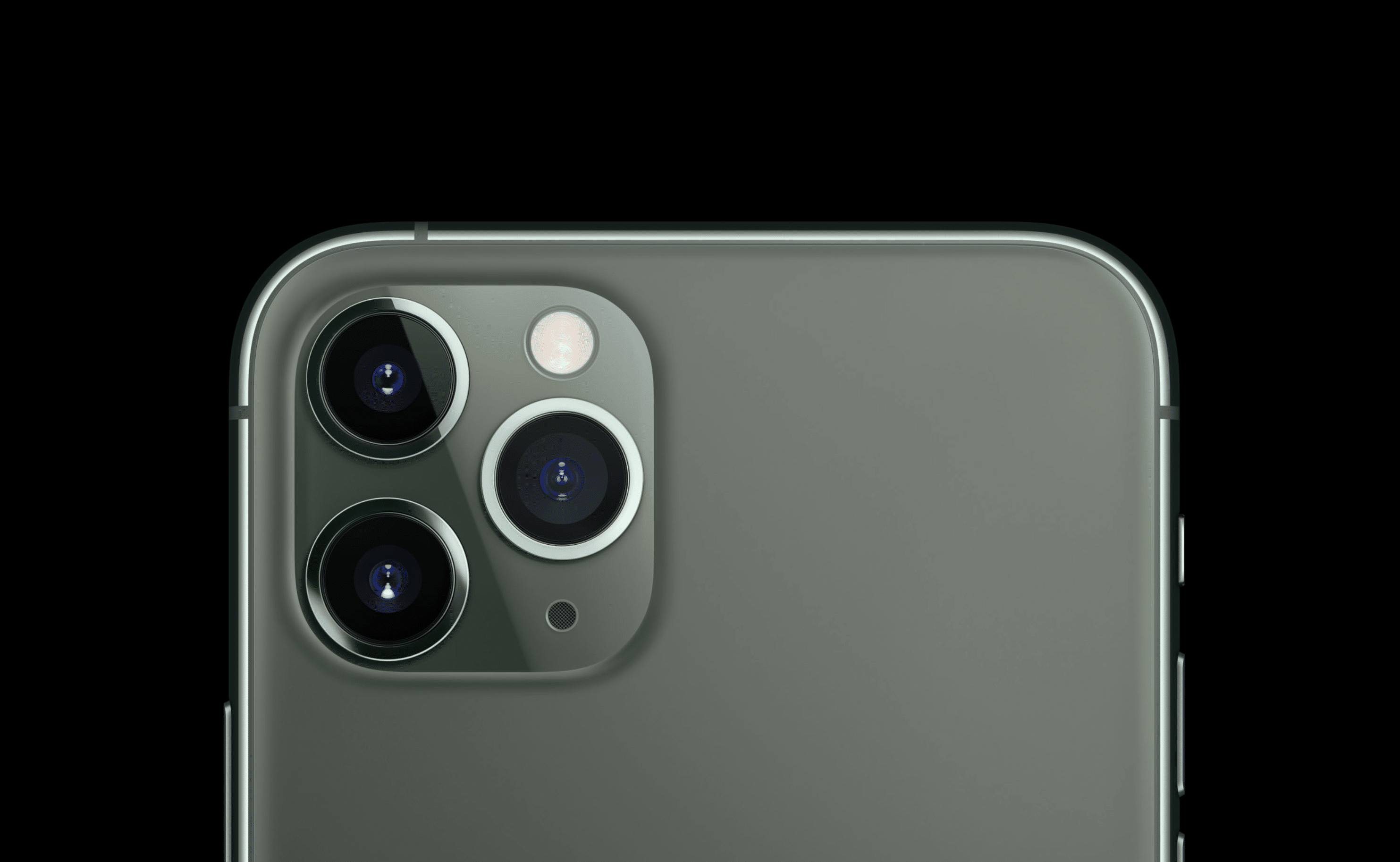 Close-up view of the top rear section of an iPhone 11 Pro Max featuring a metallic finish and a triple camera setup. The three camera lenses and a flash are arranged in a triangular pattern. The background is solid black, making the phone's design stand out, as highlighted by Consumer Reports' best smartphone ranking.