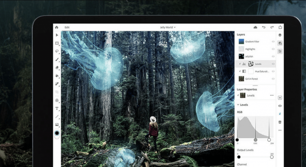 A person wearing a hat stands in a dense forest, looking up at giant, glowing jellyfish floating above. The scene is displayed on a tablet screen with Adobe Photoshop for iPad open, showcasing editing tools and layer properties, indicating digital artwork in progress since its release date.