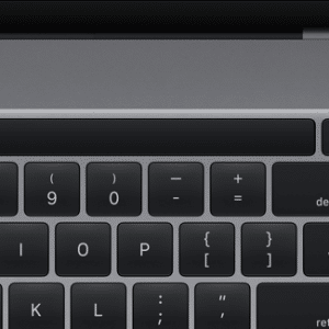 A close-up of a 16-inch MacBook Pro keyboard shows the top-left portion with number keys, special characters, and the delete key. The Touch Bar is prominently featured above the layout. The speaker grille is partially visible on the right side.