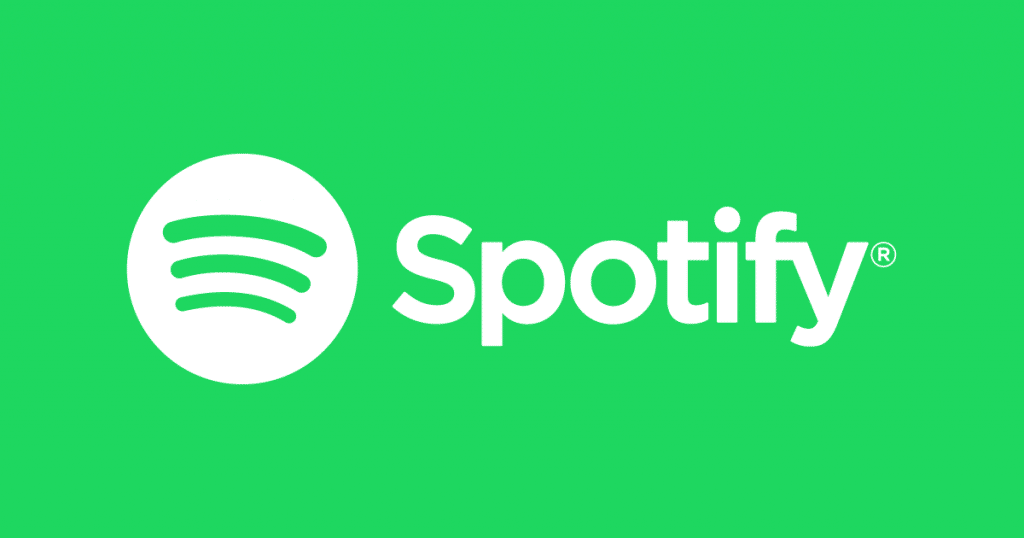 The Spotify logo, featuring a green background with a white circle containing three curved lines representing sound waves and the word "Spotify" in white text to the right of the circle, effortlessly distinguishes it from other default music apps like Apple Music.