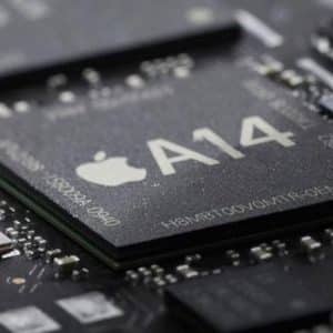Close-up image of an A14 Bionic chip on a circuit board, displaying the Apple logo and the label "A14." The chip is surrounded by other electronic components, highlighting the intricate details of the board's layout.