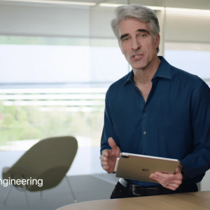 A man with gray hair wearing a blue shirt stands in an office at Apple Campus holding an iPad Pro. The text on the left reads "Craig Federighi, SVP, Software Engineering." The background features large windows and chairs.