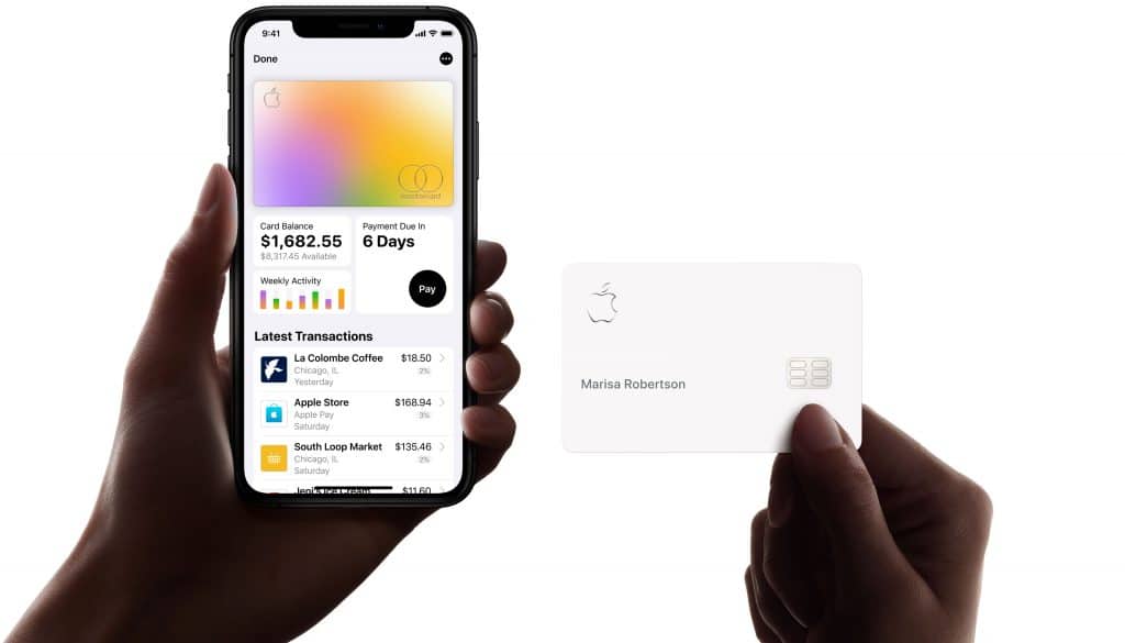 A person holds an iPhone displaying a credit card management app, showing a balance of $1,862.25 and recent transactions, including a missed March payment. Another hand holds a physical Apple Card with the name "Marisa Robertson" and the Apple logo.