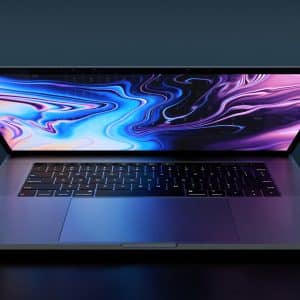 A sleek, open laptop on a dark surface displays an abstract, colorful, and swirling digital background. The laptop has a backlit keyboard and a reflective screen, casting a soft glow that complements the vibrant hues of the display—making it an ideal addition to any tech wishlist before the release of macOS 10.16.