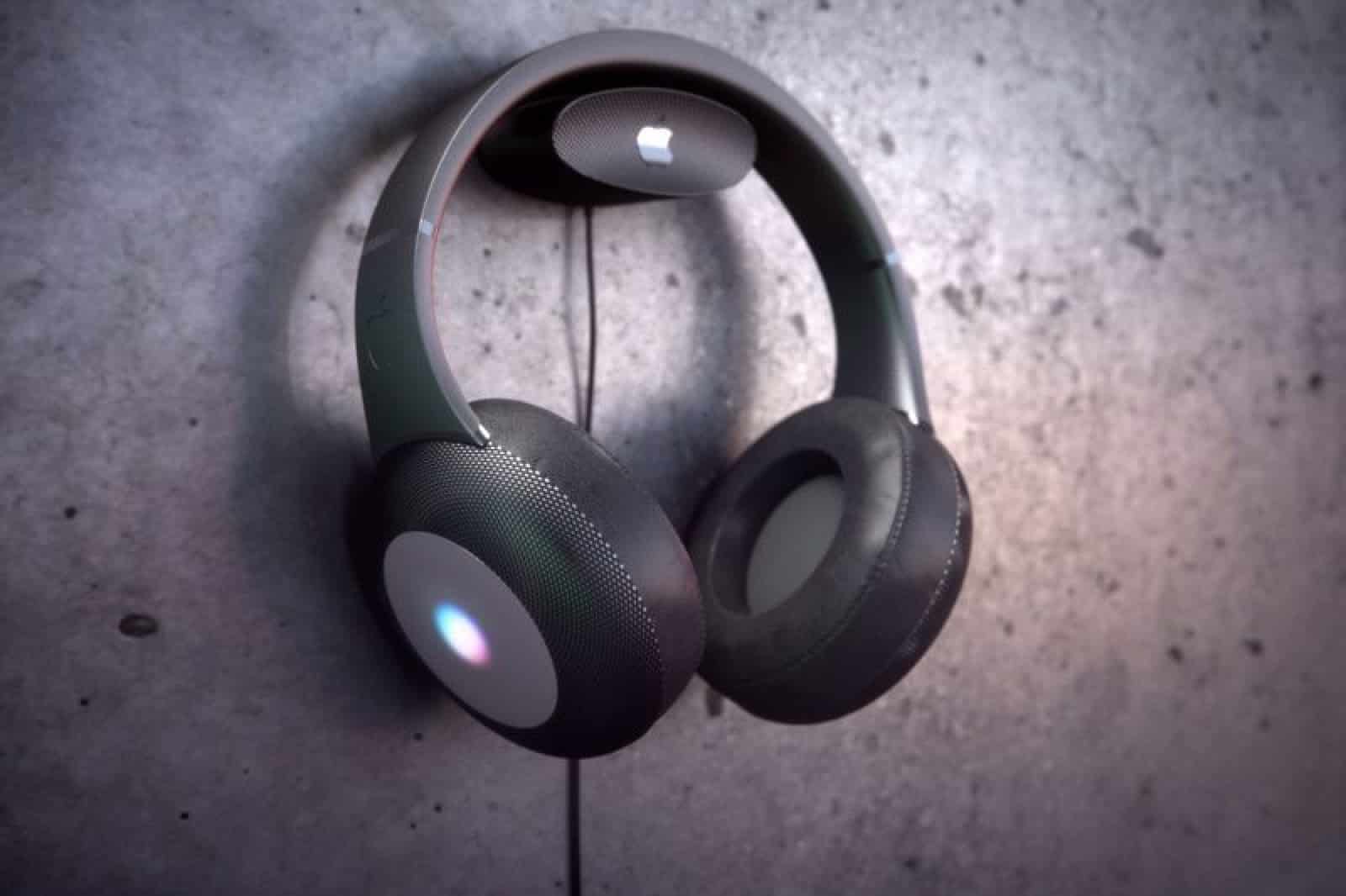 A pair of sleek, modern StudioPods over-ear headphones with a gray and black color scheme hanging on a concrete wall. The ear cups feature a subtle circular design and soft padding for comfort, with swappable parts and a small white logo displayed on the side.