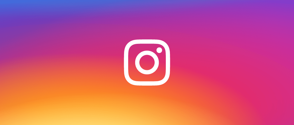 Instagram logo displayed centrally on a gradient background transitioning from blue at the top, through purple and pink, to orange and yellow at the bottom. The iconic white outline of a camera with a circle and a small dot on the top right perfectly encapsulates Instagram's vibrant appeal to attract followers.