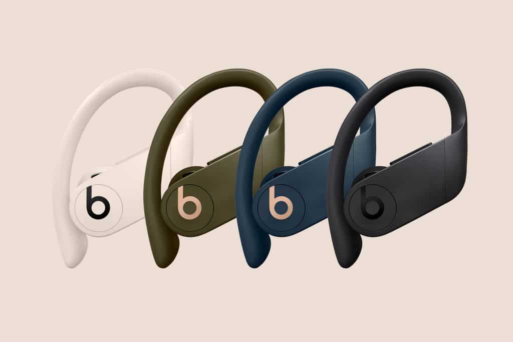 Four Beats by Dre Powerbeats Pro wireless earphones are shown, each in new colors: ivory, moss, navy, and black. The earphones feature an over-ear hook design for a secure fit and have the Beats logo prominently displayed on the side. Experience Apple-quality sound with every beat.