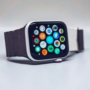 A number one smartwatch with a rectangular face and dark strap is displayed on a smooth surface, reminiscent of the popular Q1 2020 models. Its screen showcases various colorful app icons arranged in a grid, much like the Apple Watch.