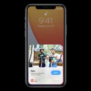 An iPhone displaying its lock screen with the date Monday, June 22 and time 9:41. The screen shows an app suggestion for "Spin," featuring an image of two people with bicycles and a button labeled "Open." A notification icon is visible at the bottom left, showcasing new features like App Clips introduced in iOS 14.