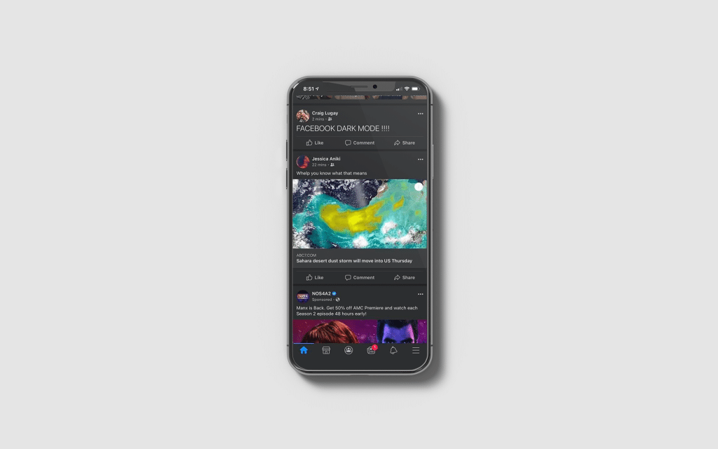 A smartphone running iOS displays Facebook in dark mode. The screen shows a post about the dark mode feature, alongside an image of a colorful swirl and a NASA news headline about Saturn. Various icons are visible at the bottom.