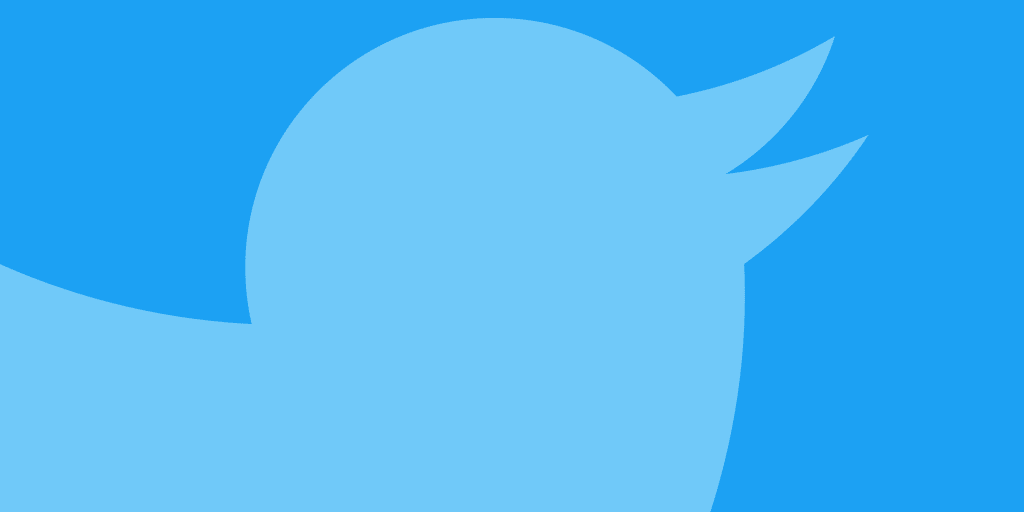 A light blue bird silhouette on a darker blue background. The bird, facing right, is depicted with a round body, pointed beak, and wing extended back, forming a stylized logo that instantly evokes thoughts of Twitter verification and what it means to get verified on the platform.