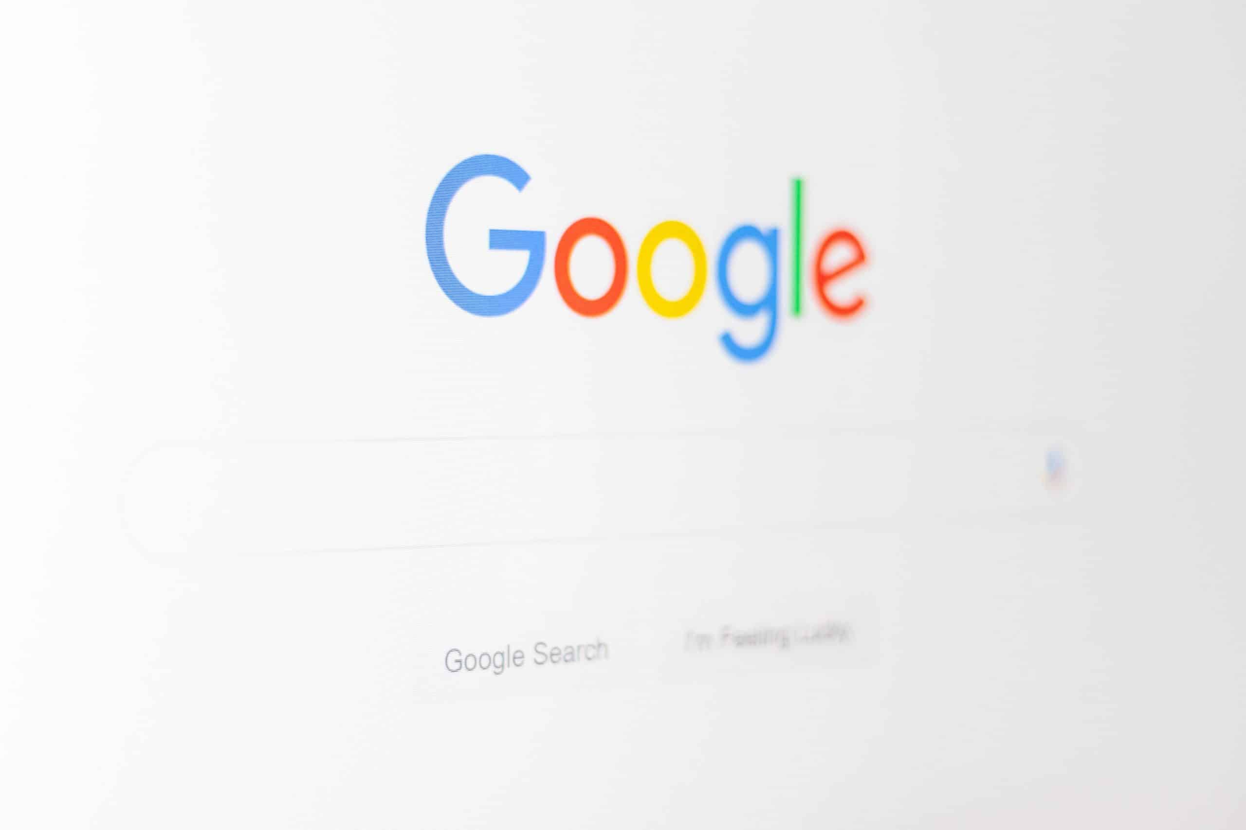 A screenshot of the Google homepage, displaying the colorful Google logo above the search bar. Below the search bar are two buttons labeled "Google Search" and "I'm Feeling Lucky." The background is plain white, with subtle hints of Google Content Highlighting in action.