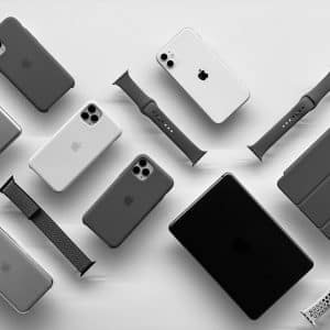 A monochrome image featuring various Apple products displayed on a white surface. Items include multiple iPhones, an iPad, an Apple Watch, AirPods, watch bands, and a MacBook. All products are arranged in a neat, organized manner.