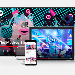 Image showing the streaming of the TV show "The Masked Singer" on various devices, including a TV, laptop, and smartphone. The TV screen features colorful masked characters, while the laptop and smartphone display the show's interface on YouTube TV amidst concerns about a possible price hike in the US.