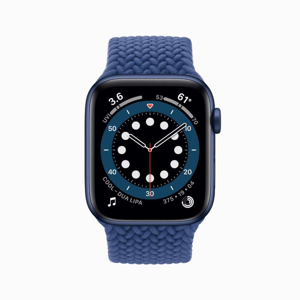 A blue Apple Watch with a braided solo loop band displays an analog watch face with white dots and numerals around the edge. The screen also shows additional information including temperature, UV index, music, energy rings, and date.